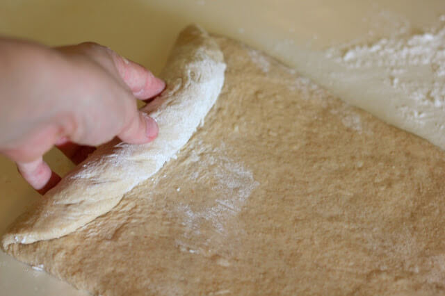 hand rolling bread dough into a tube