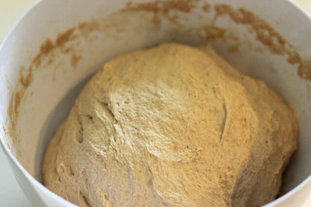 kneaded bread dough in a white bowl