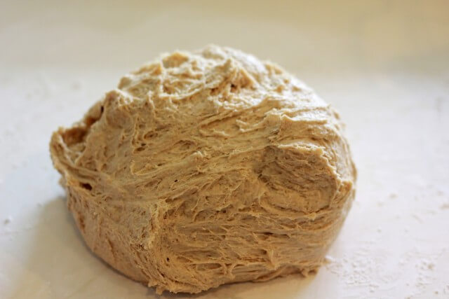 bread dough being kneaded on a countertop