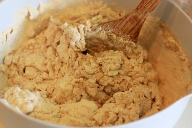 bread dough being mixed with a wooden spoon