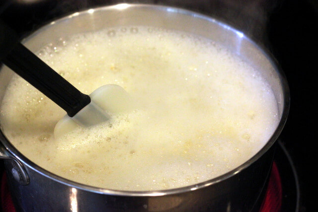 boiling pot with garlic cloves, onion, soap and cayenne pepper