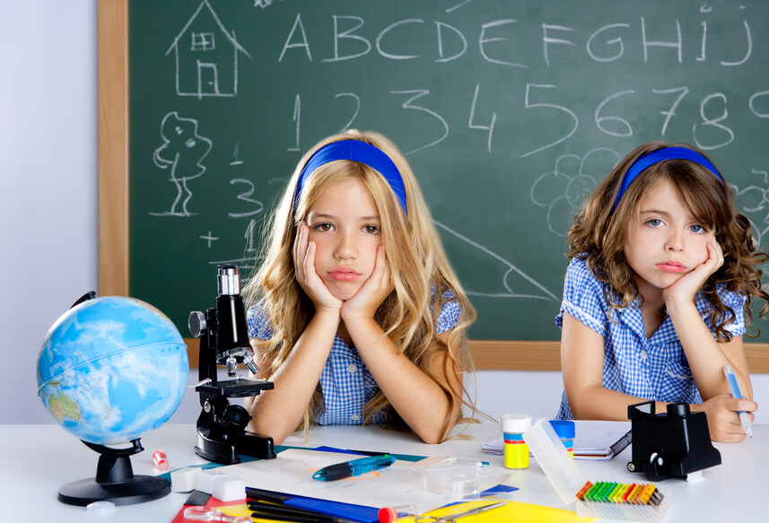 Bored student kids at school classroom in desk