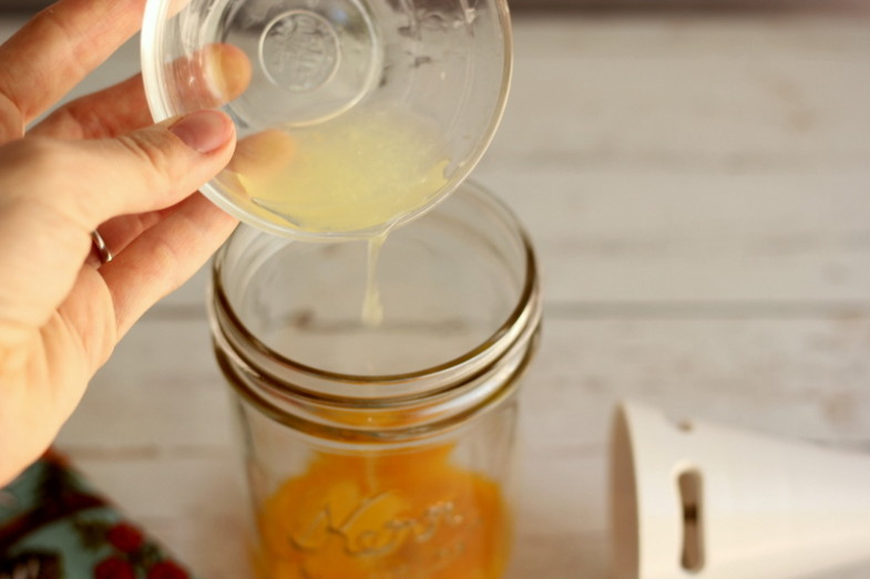 lemon juice being poured into a glass jar