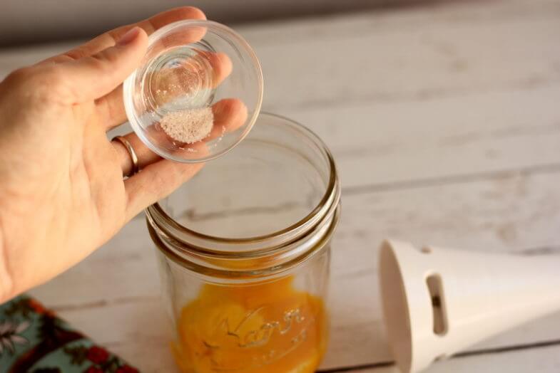 salt eing poured into a glass jar