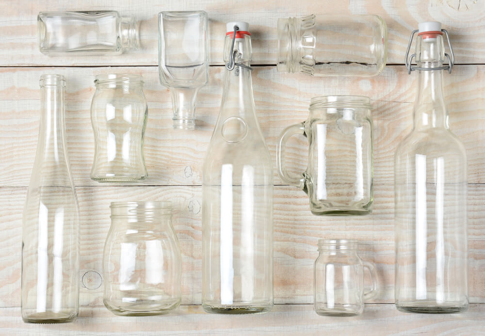 Various bottles and containers on a white painted table.