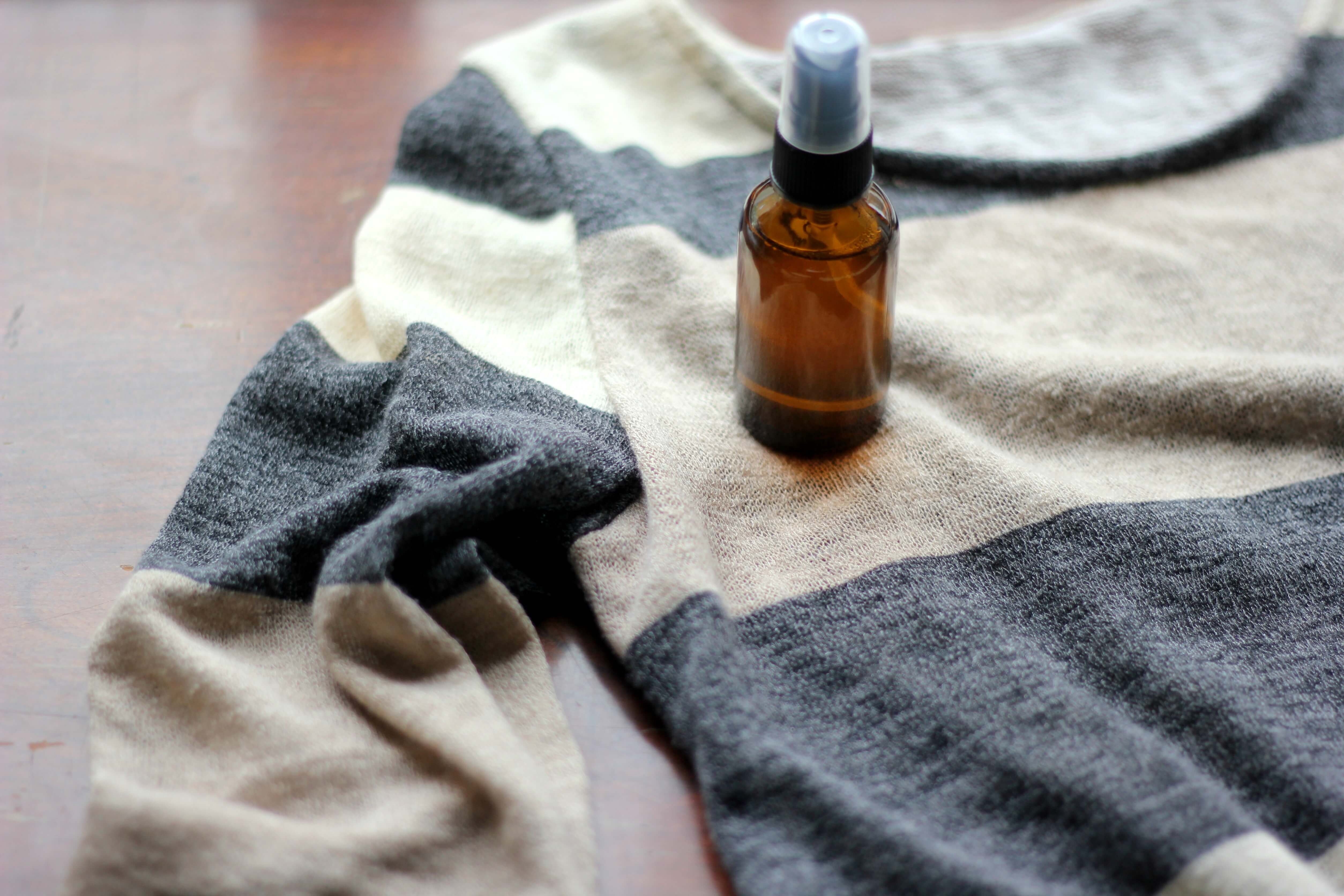 bottle filled with oil on a striped shirt on a table