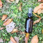 essential oil bottle on clovers and dried leaves