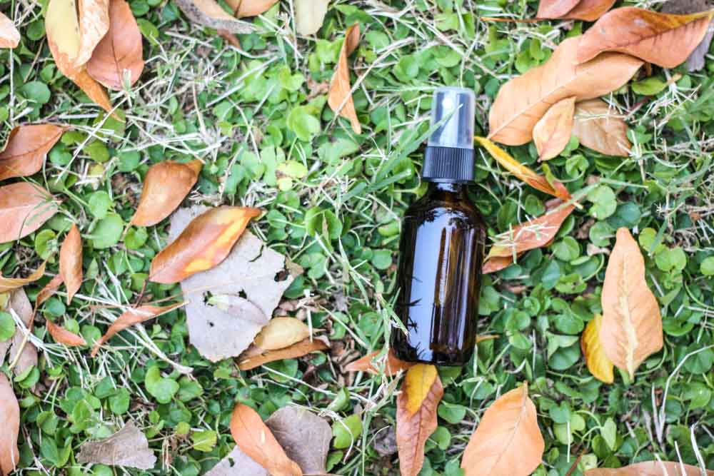 essential oil bottle on clovers and dried leaves