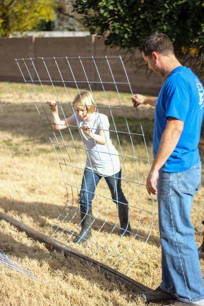 young woman and adult man assembling a trellis