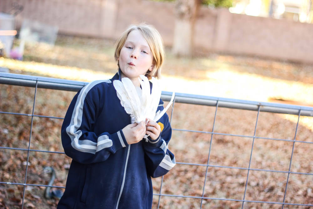 young teenager playing with bird feathers