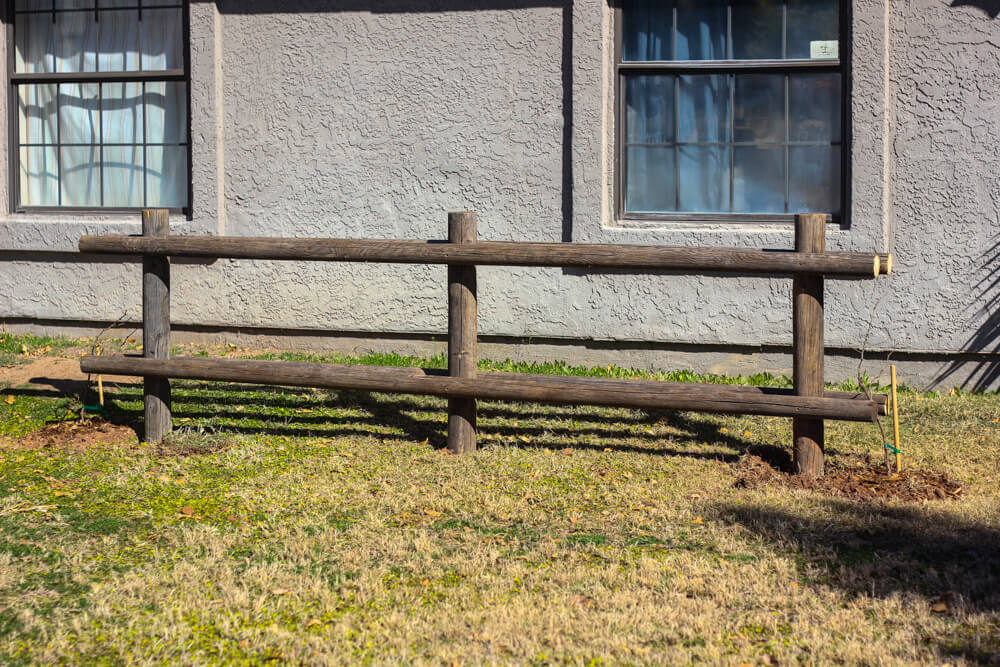 wooden pole fence in backyard against house