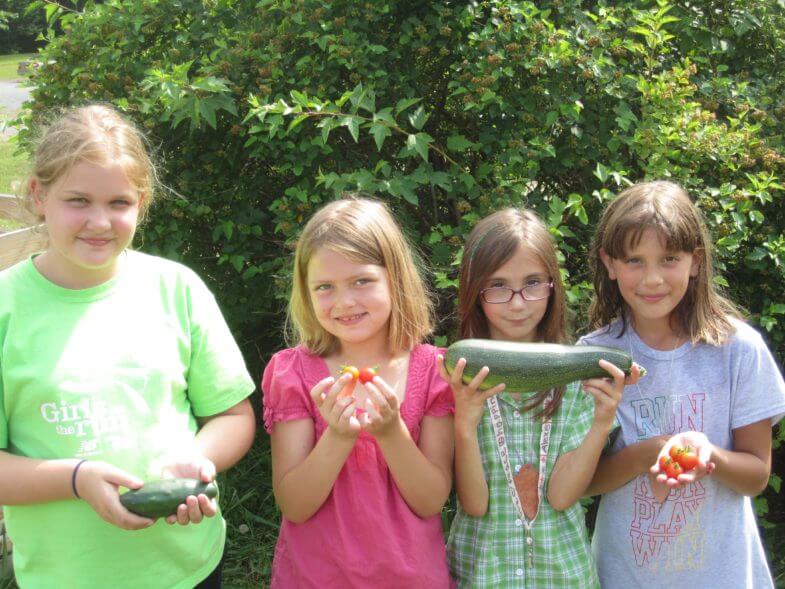 kids holding up vegetables