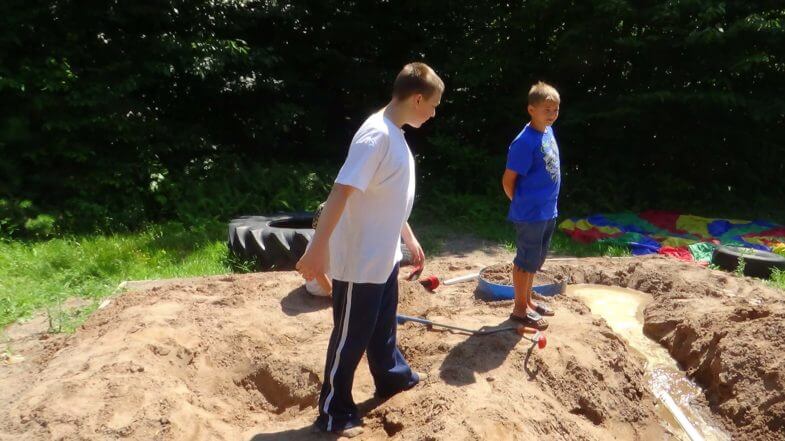 kids playing in a large raised sandbox