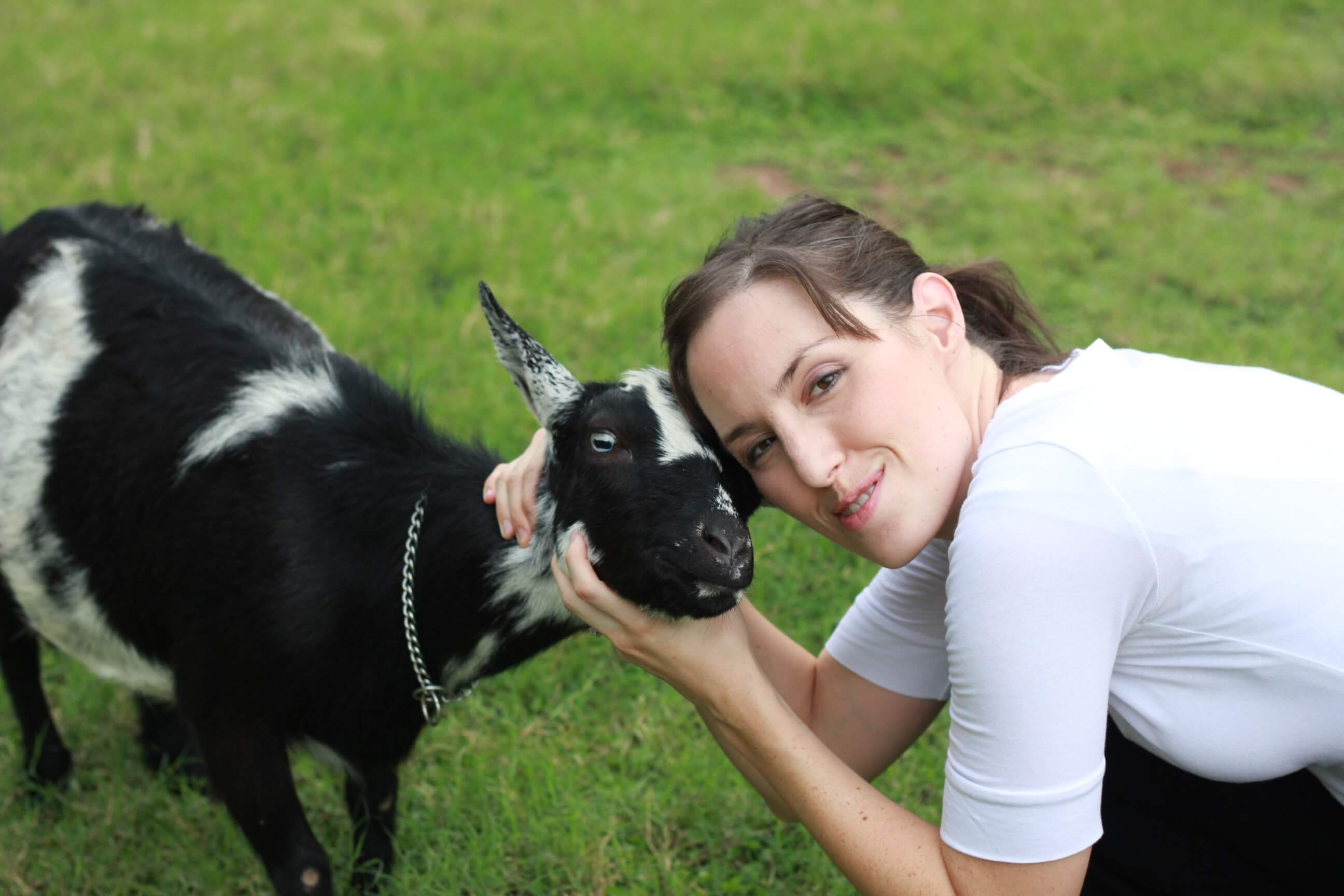 DaNelle cuddling a black and white goat kid