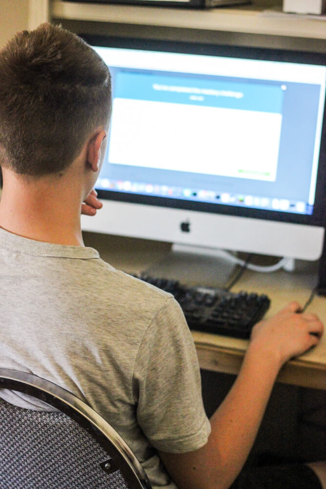 student in t-shirt at computer