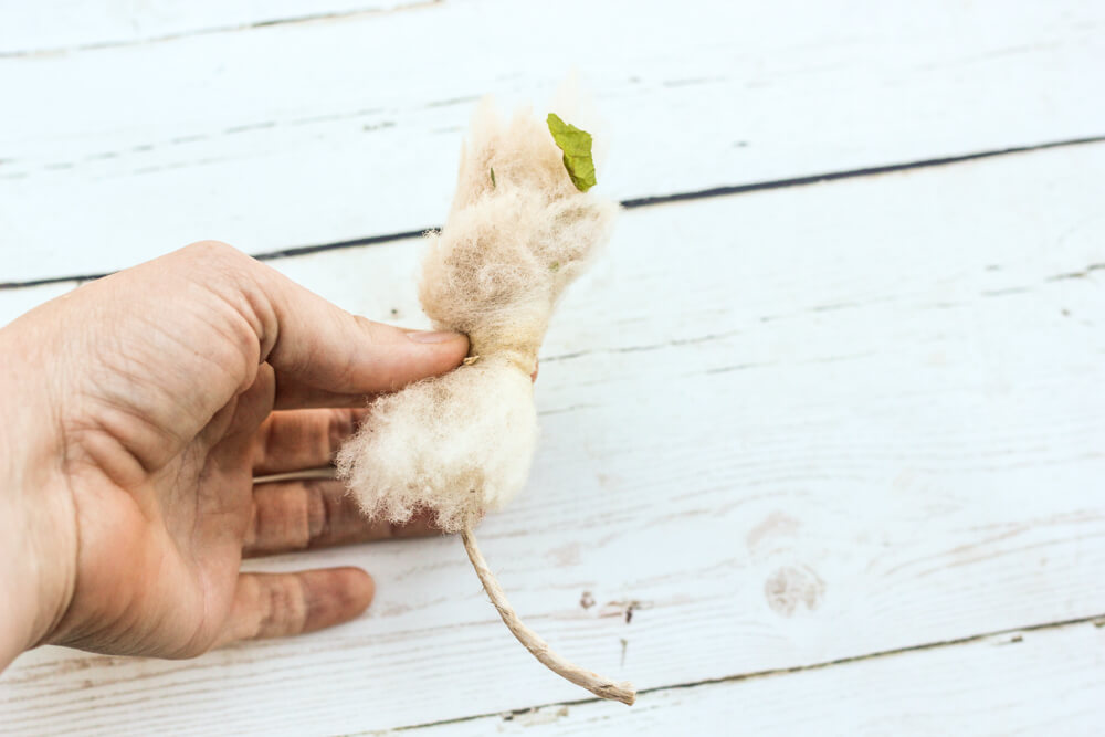 hand holding wool tampon with small leaf detail