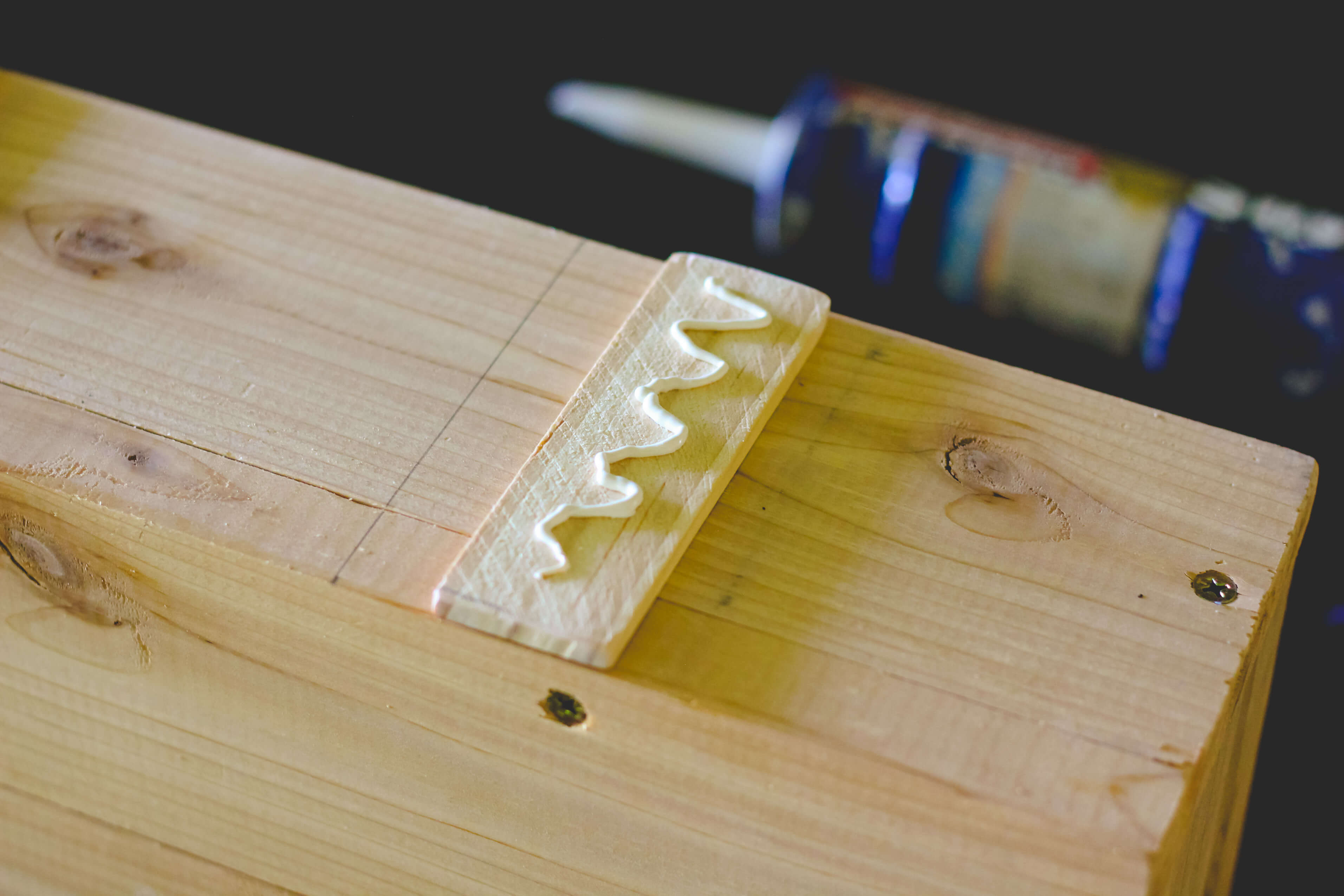 Gluing trim on wood succulent planter.