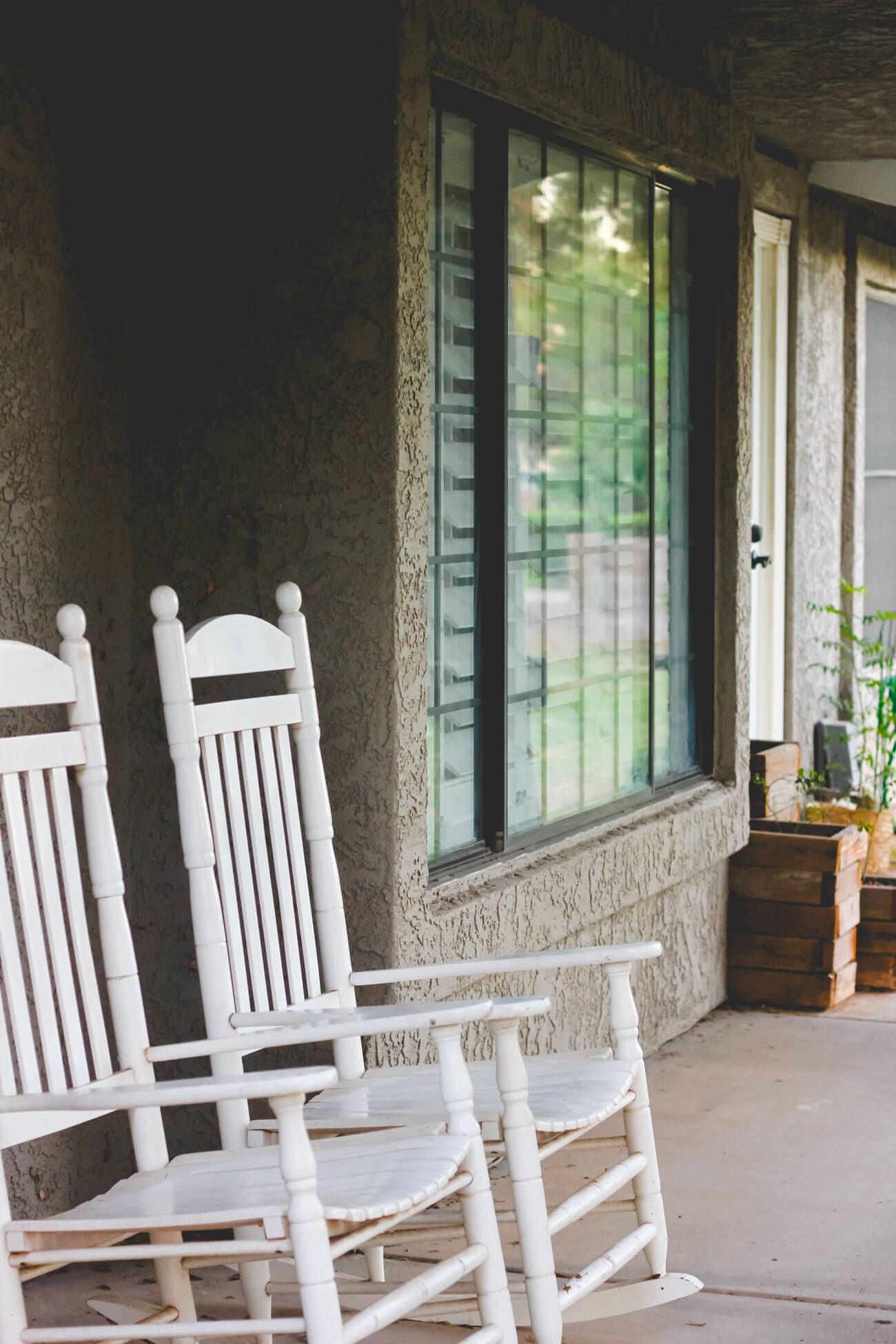 Grey farmhouse porch with planters & shutters